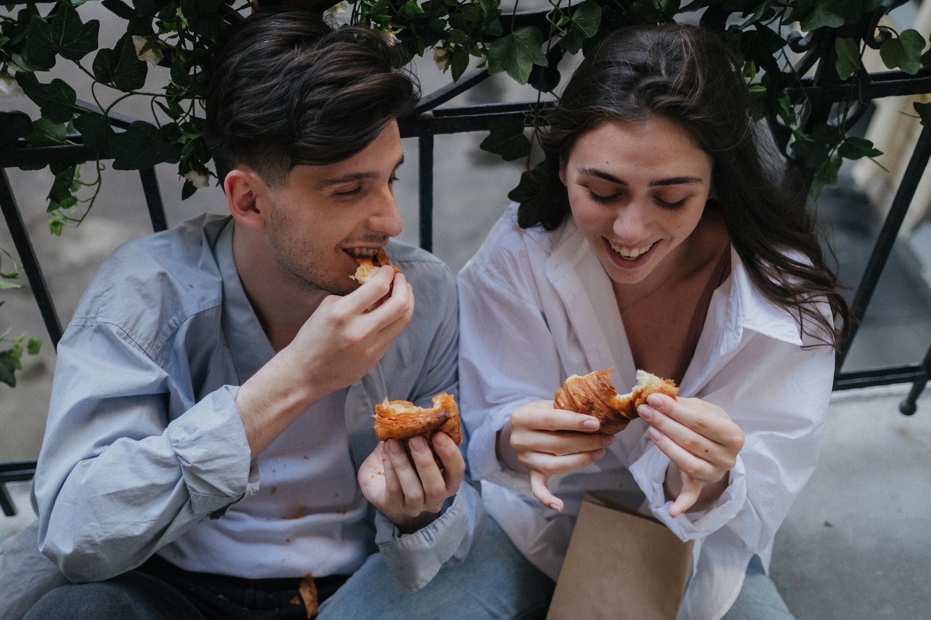 two people eating croissants